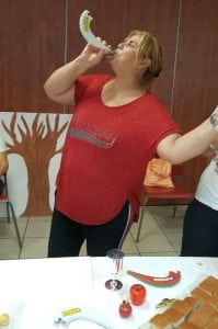 אישה בחולצה אדומה תוקעת בשופר