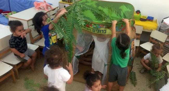מעון הנשיאים באר שבע. ילדים מקימים דגם של סוכה במעון