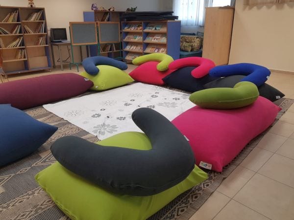 מעגל של כריות ופופים ססגונים מסודרים על רצפה ובמרכז מפה