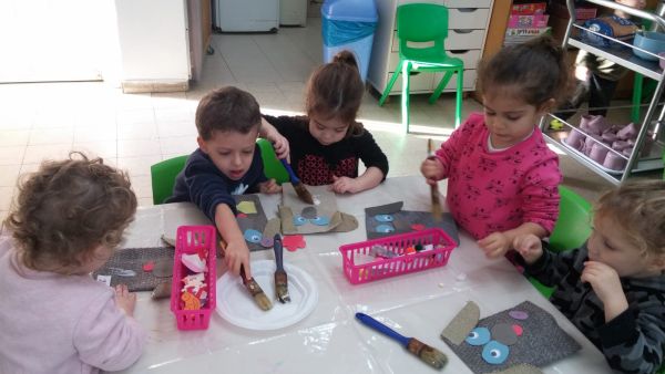 ילדים סביב שולחן עם מכחולים ודבק יוצרים