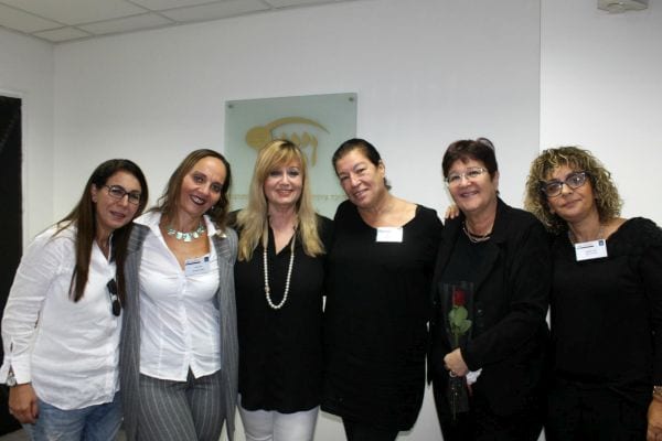 שש נשים מתחבקות ומחייכות למצלמה נעמי במרכז