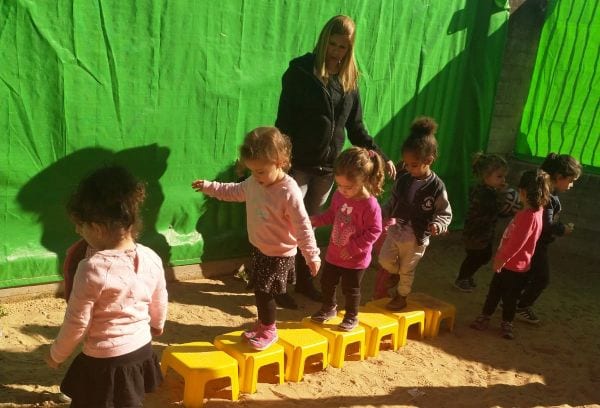 ילדים בחצר הולכים על רכבת שרפרפים