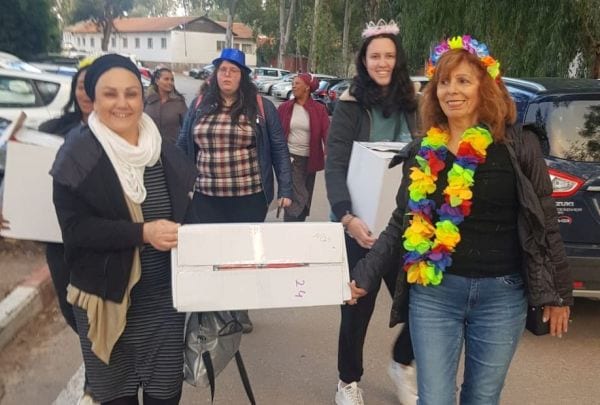 נשים פוסעות על שביל והן נושאות חבילות